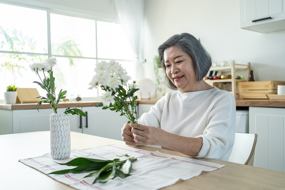 asian senior old woman puts flowers on vase with h 2021 12 09 20 23 02 utc
