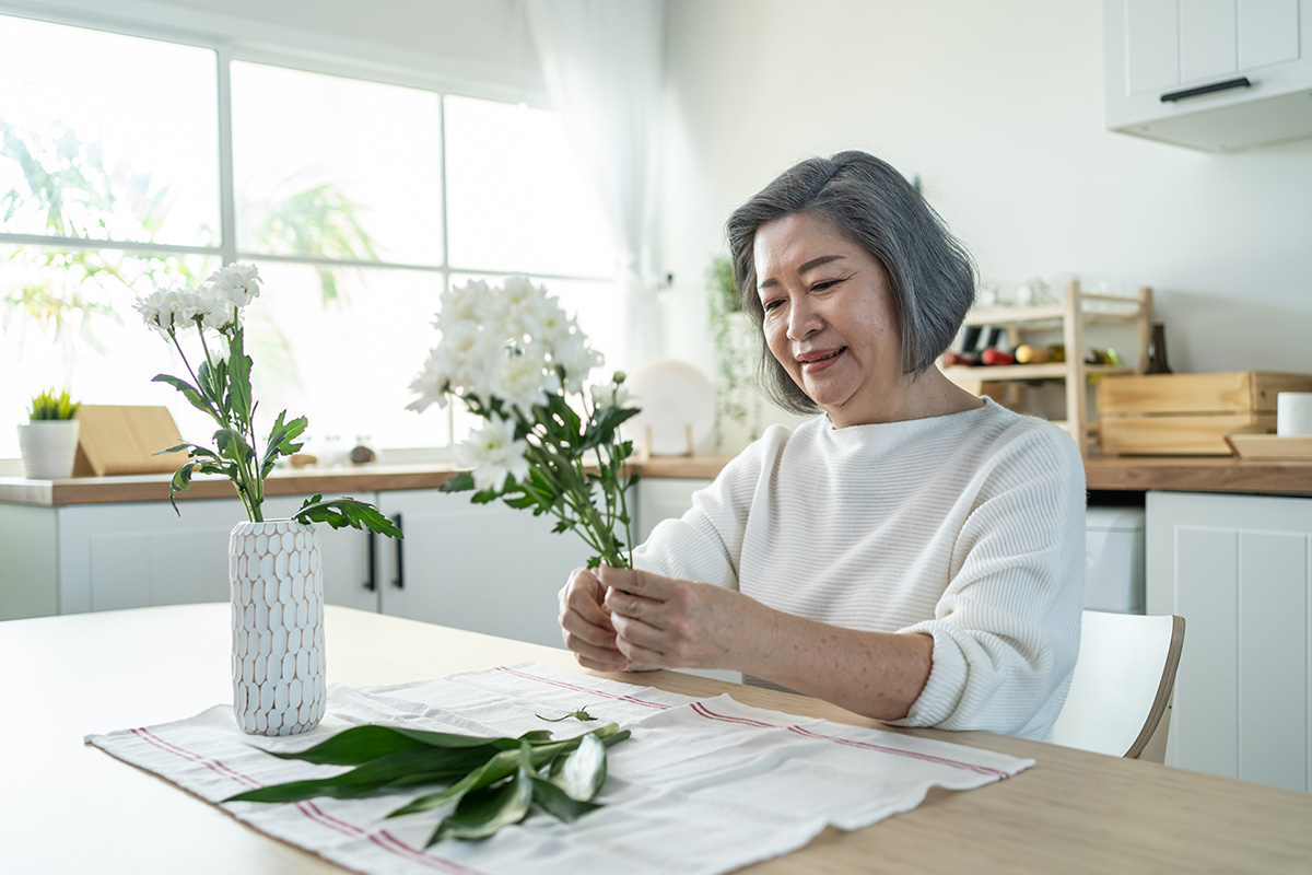 une vieille femme âgée asiatique met des fleurs sur un vase avec h 2021 12 09 20 23 02 utc