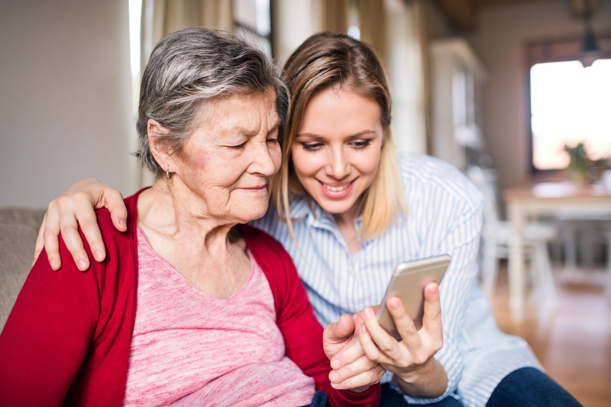 elderly grandmother and adult granddaughter look for senior apartments