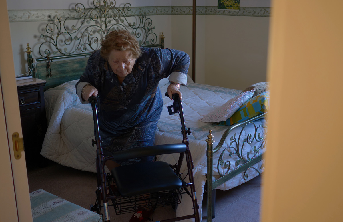 elderly woman in bedroom of low income senior apartment