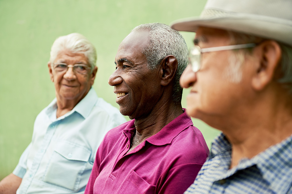 grupo de viejos hombres negros y caucásicos hablando en pa