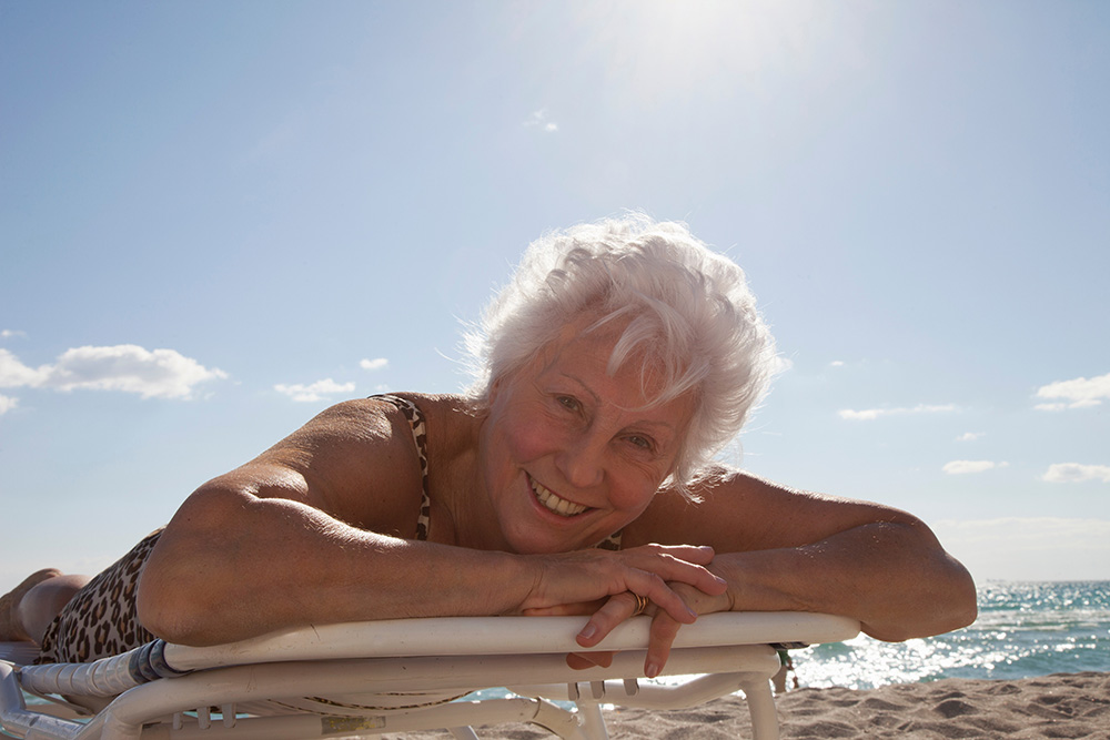 mujer mayor disfrutando en la playa