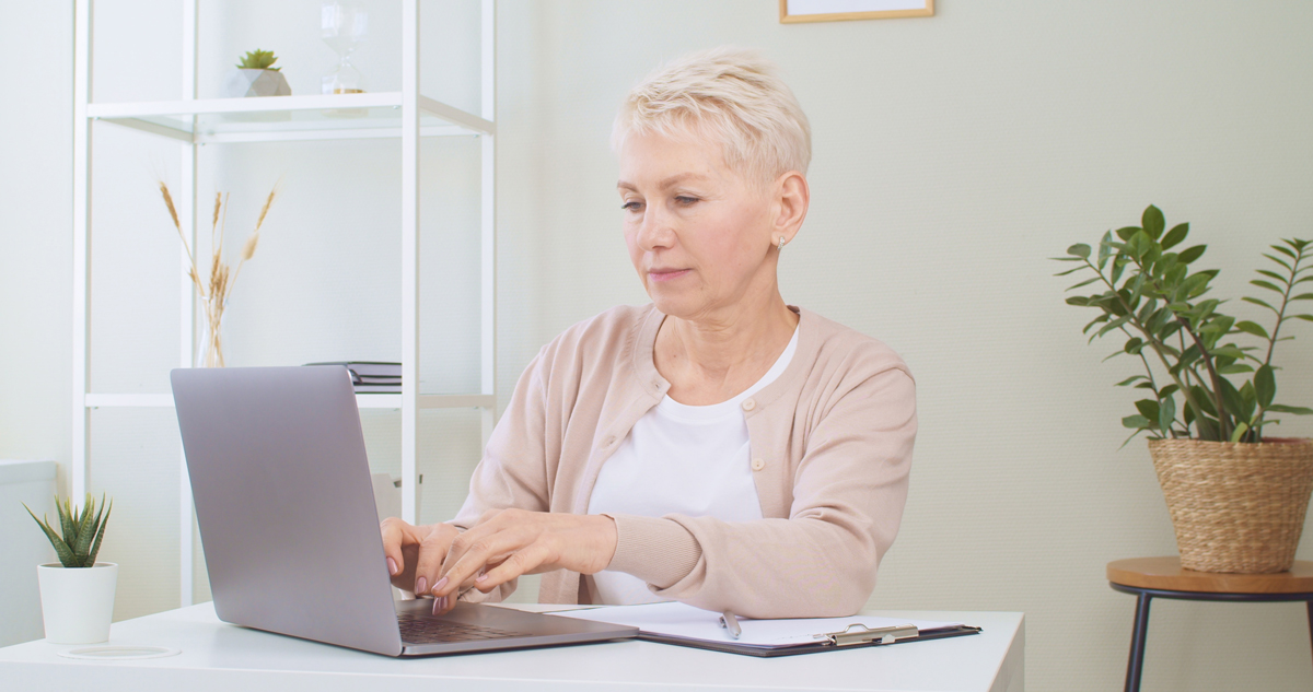 mujer mayor que usa una computadora portátil para encontrar un apartamento para personas mayores de bajos ingresos