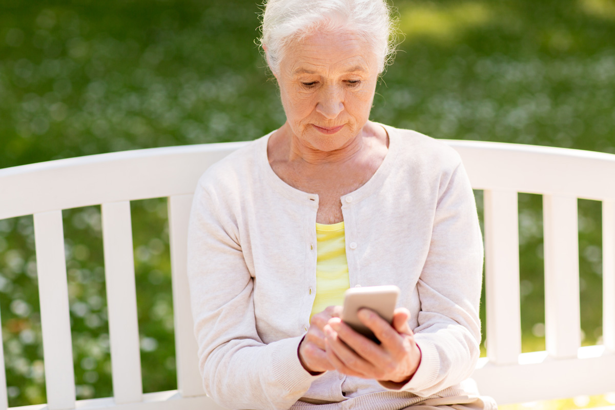 senior woman with smartphone searching for senior apartments