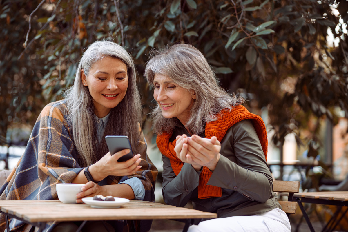 una anciana asiática sonriente muestra senioridy por teléfono